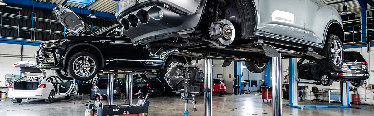 Innenansicht Werkstatt mit Fahrzeugen auf Hebebühnen